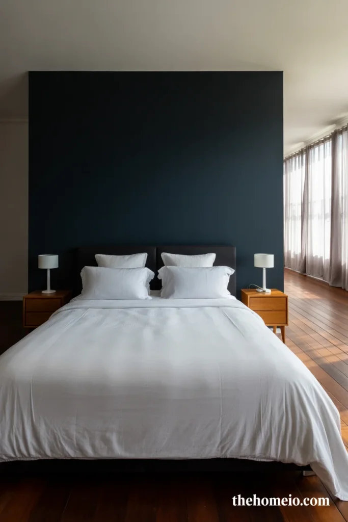Classic black accent wall behind bed with white bedding warm wood nightstands and white lamps in modern bedroom