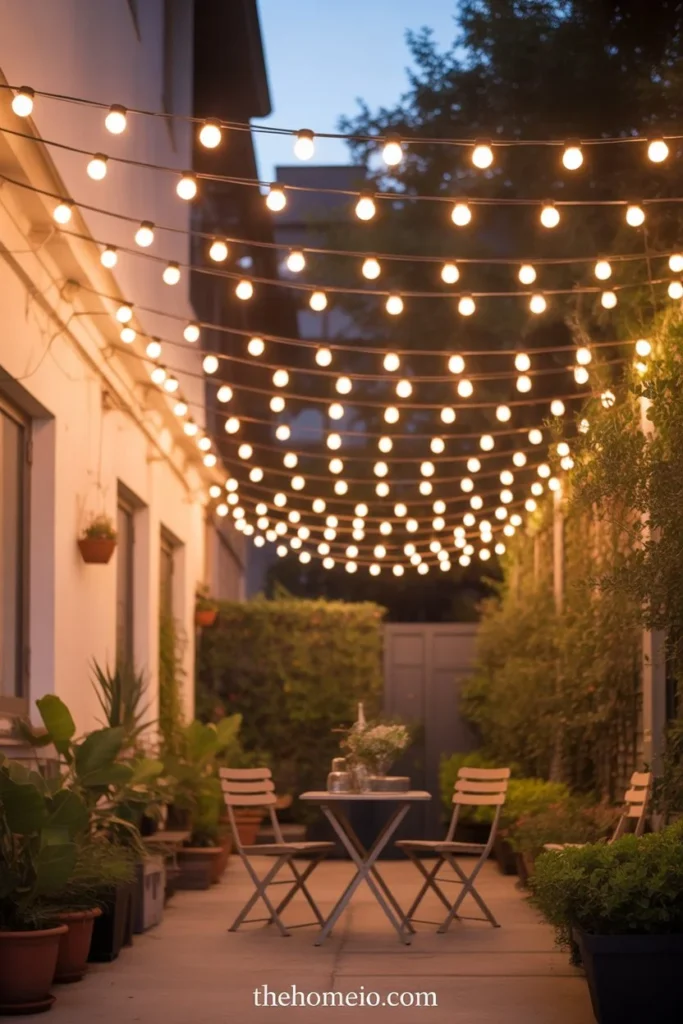 Charming small , backyard patio at dusk with globe bistro lights hung at 9 feet creating warm intimate cafe-style lighting canopy